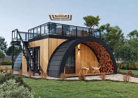 Exterior visualization of a modern Terrace house with a green roof. The building features a wooden facade and rounded elements covered with a dark roof. It has two terraces: a covered one at ground level with wicker armchairs and an open rooftop terrace with an umbrella and lounge furniture, accessible via external stairs. A well-maintained lawn and vegetation surround the house.