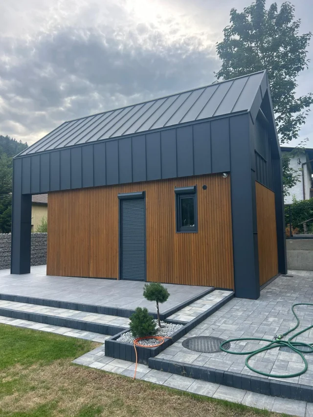 Ekodom50: widok na patio i mały ogród w pochmurny dzień.