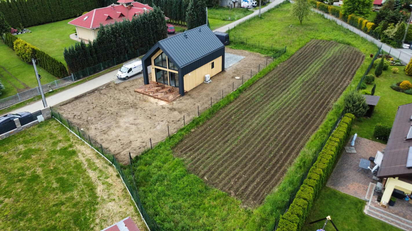 Construction maison ossature bois à Żywiec, façade planche/tôle, grand terrain.