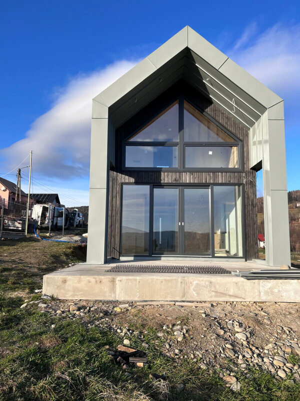 Maison u00e0 ossature bois u00e0 u00e9conomie d'u00e9nergie avec grandes fenu00eatres de pignon, en construction.