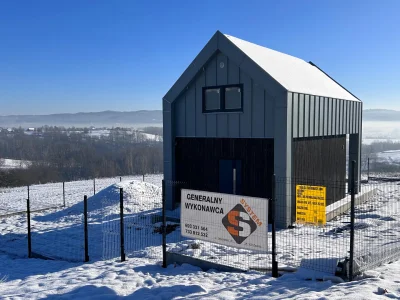 Tylna elewacja Ekodom 50, dach popiel, czarna deska, tablica budowy.