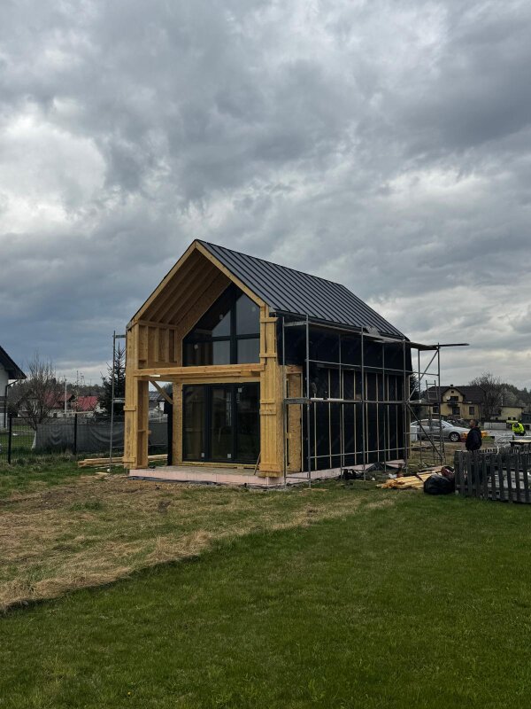 Realizacja domu szkieletowego w Cięcinie z zamontowanym dachem z blachy na rąbek i widocznym szkieletem konstrukcyjnym budynku