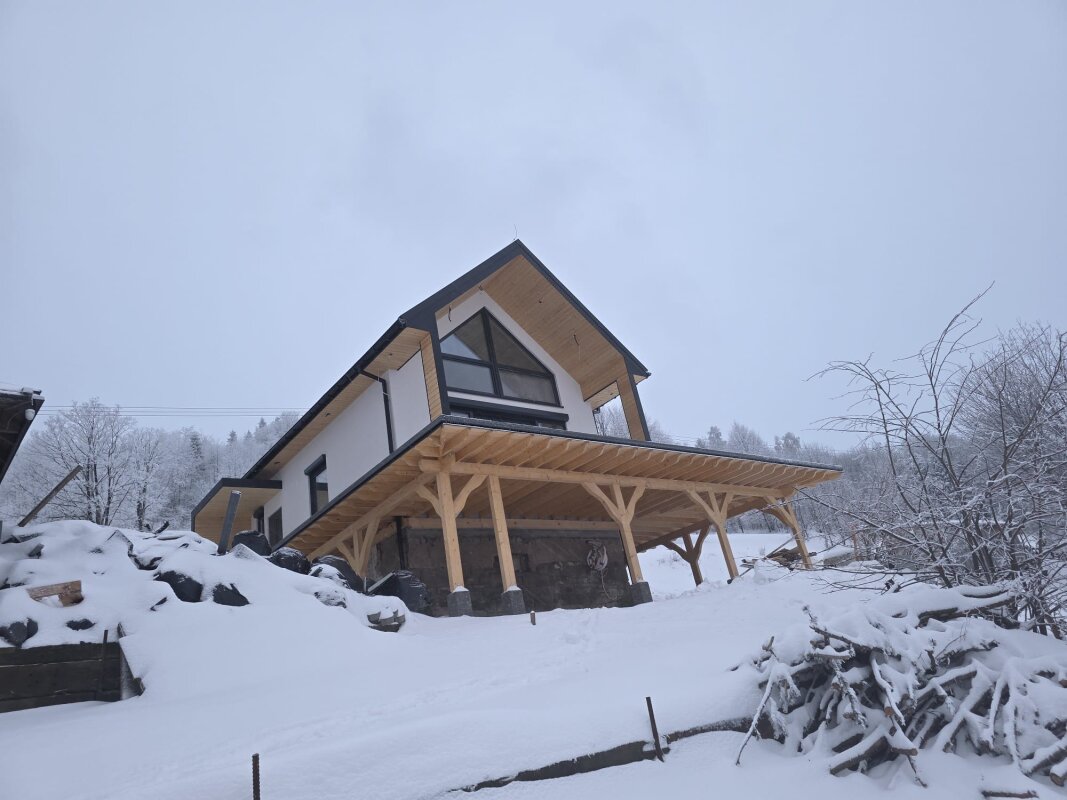 Szczyt domu: okna trapezowe, taras nad skarpą.