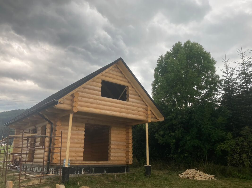 Holiday house from spruce log in Brenna, finished roof and covered terrace.