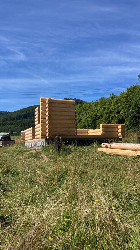 Construction of a spruce log house on foundation; mountain area, beautiful sunshine.