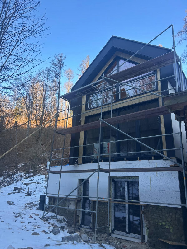 Haus während Dämmung, Verglasung, traufenlos.