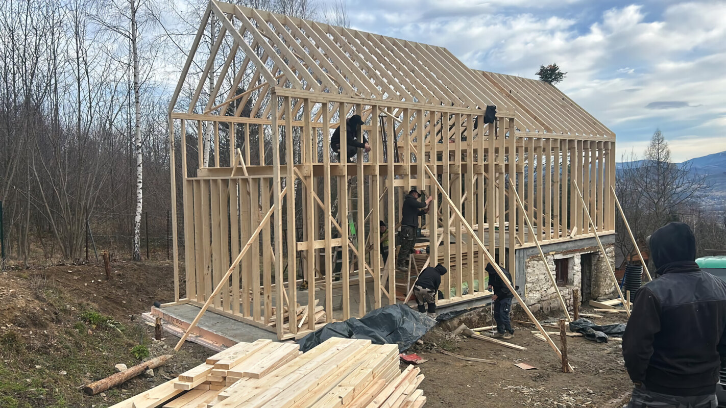 Team assembling the timber frame structure of the Individual house with roof in Matyska.