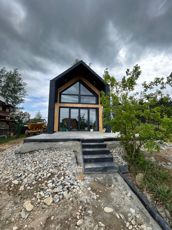 Architektur: Modulhaus Ekodom 50 mit Terrasse; Fassade aus Holz und Blech; Weitwinkel.
