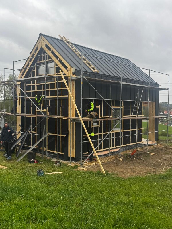 Etap prac nad projektem Ekodom 50 z widocznym montażem szkieletu drewnianego na nachylonej działce