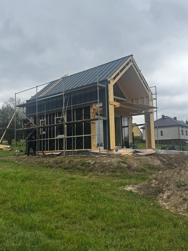 Konstrukcja nośna budynku szkieletowego z widocznym poszyciem wiatroizolacyjnym i rusztowaniem zewnętrznym