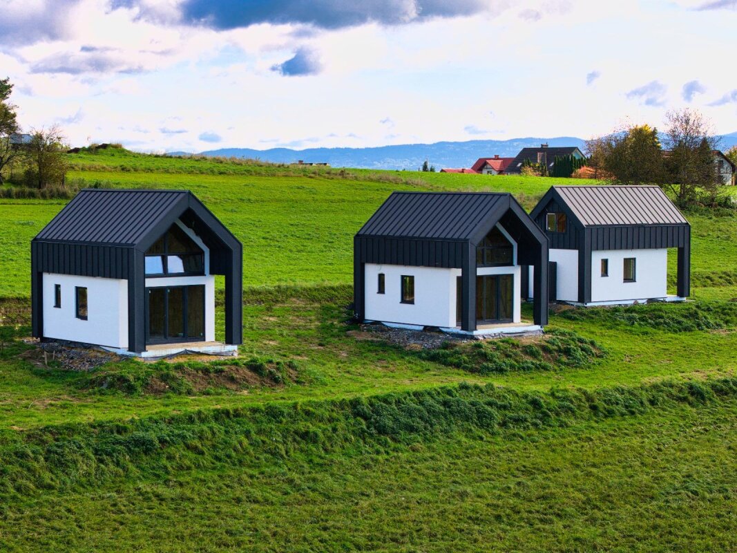 Trois maisons modulaires Ekodom 50 à Bierna, façade tôle à joint debout et enduit blanc; construction ossature bois.