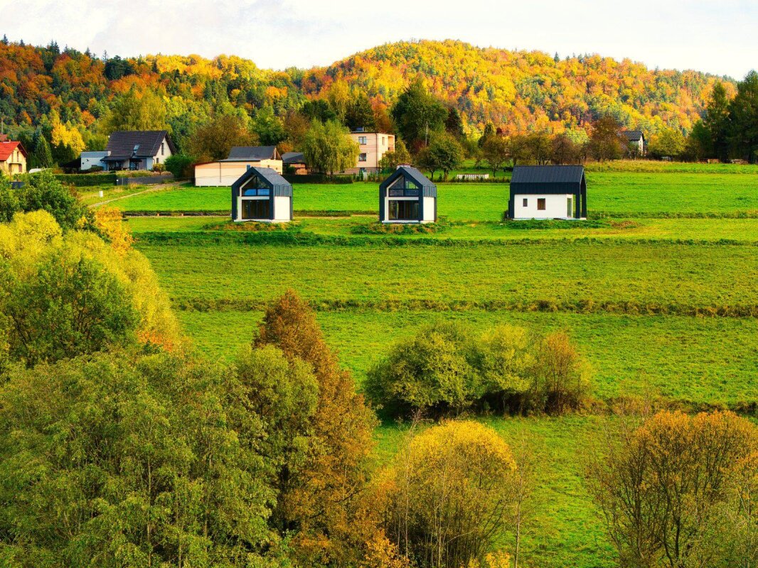Maisons modulaires Ekodom 50 à Bierna sur fond de forêt automnale; maisons individuelles ossature bois.