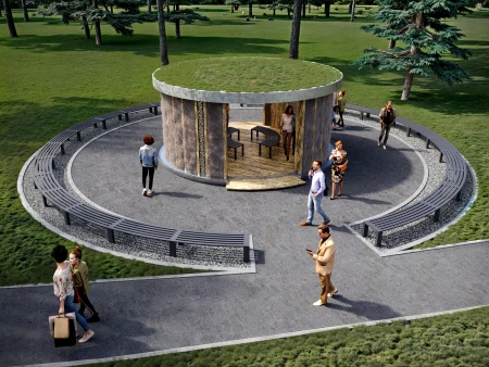 Widok z góry na okrągłą tężnię solankową Small Salty Rest z zielonym dachem porośniętym trawą, otoczoną alejką spacerową z ławkami. Wokół tężni i w jej wnętrzu spacerują ludzie. Tężnia ma elewację z naturalnych materiałów, a w tle widać drzewa i zielony trawnik.