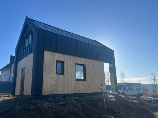 Modernes Fachwerkhaus Ekodom 50 in Limanowa; schwarzes Blech und helle Holzverkleidung.
