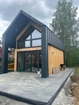 Fasada domu Ekodom 50; duże okna tarasowe; zadaszenie; zbliżenie narożnika.