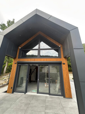 Duże przeszklenia i drzwi tarasowe w szczycie nowoczesnego domu Ekodom 50.