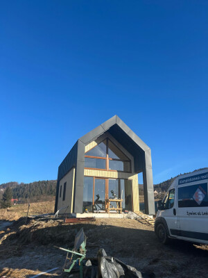Modernes Holzrahmenhaus Ekodom 50 in Węgierska Górka. Schwarzes Stehfalzblech, Holzfassadenbrett.